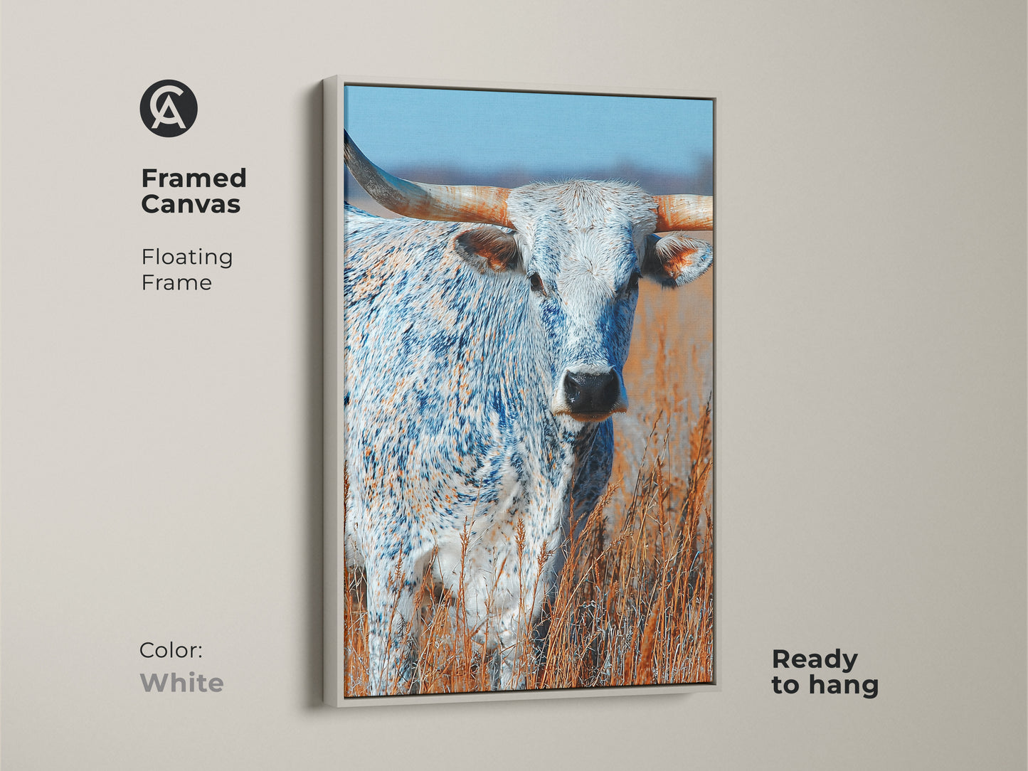 This framed canvas art features a longhorn bull. The artwork has a floating frame. The frame color is white. This canvas print is ready to hang. The animal art is a beautiful addition to any space.