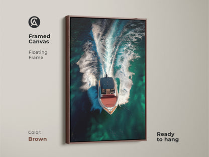Framed canvas displaying aerial speedboat artwork with a brown floating frame. The emerald green ocean wall art captures turquoise waters. Ready to hang this contemporary nautical art is perfect for a boating gift idea.
