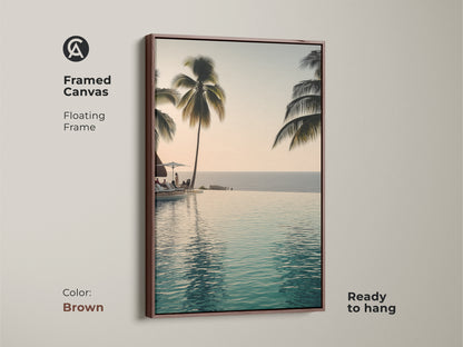 This framed canvas features an infinity pool with palm trees. A floating frame in brown makes it ready to hang. Enjoy a coastal ocean view with this tropical beach landscape artwork.