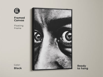 Framed canvas of a monochrome face portrait with a black floating frame. Ready to hang this intense gaze canvas art adds a contemporary touch. The expressive eyes artwork is perfect for modern monochrome decor. Enhance your entryway with this bold black and white print.