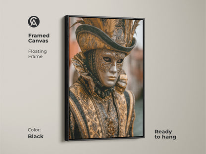 Framed canvas featuring a Venetian mask. This baroque costume artwork has a black floating frame. The gold and black artwork is ready to hang. Add an eclectic touch to your entry hall with this historical masquerade artwork. A perfect festival gift.