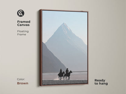 Framed canvas presents a minimalist cowboy and horse silhouette. Brown floating frame enhances the rustic charm. Misty blue mountain landscape brings a serene touch. Perfect wall art for those who love western adventure. Ready to hang art.