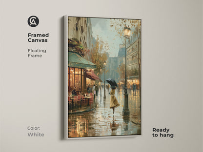 Framed canvas of a rainy Paris cafe scene in a white floating frame. This contemporary artwork features an impressionistic cityscape. The European street scene decor showcases a woman with an umbrella. This ready to hang art adds a touch of vintage charm to your home decor.