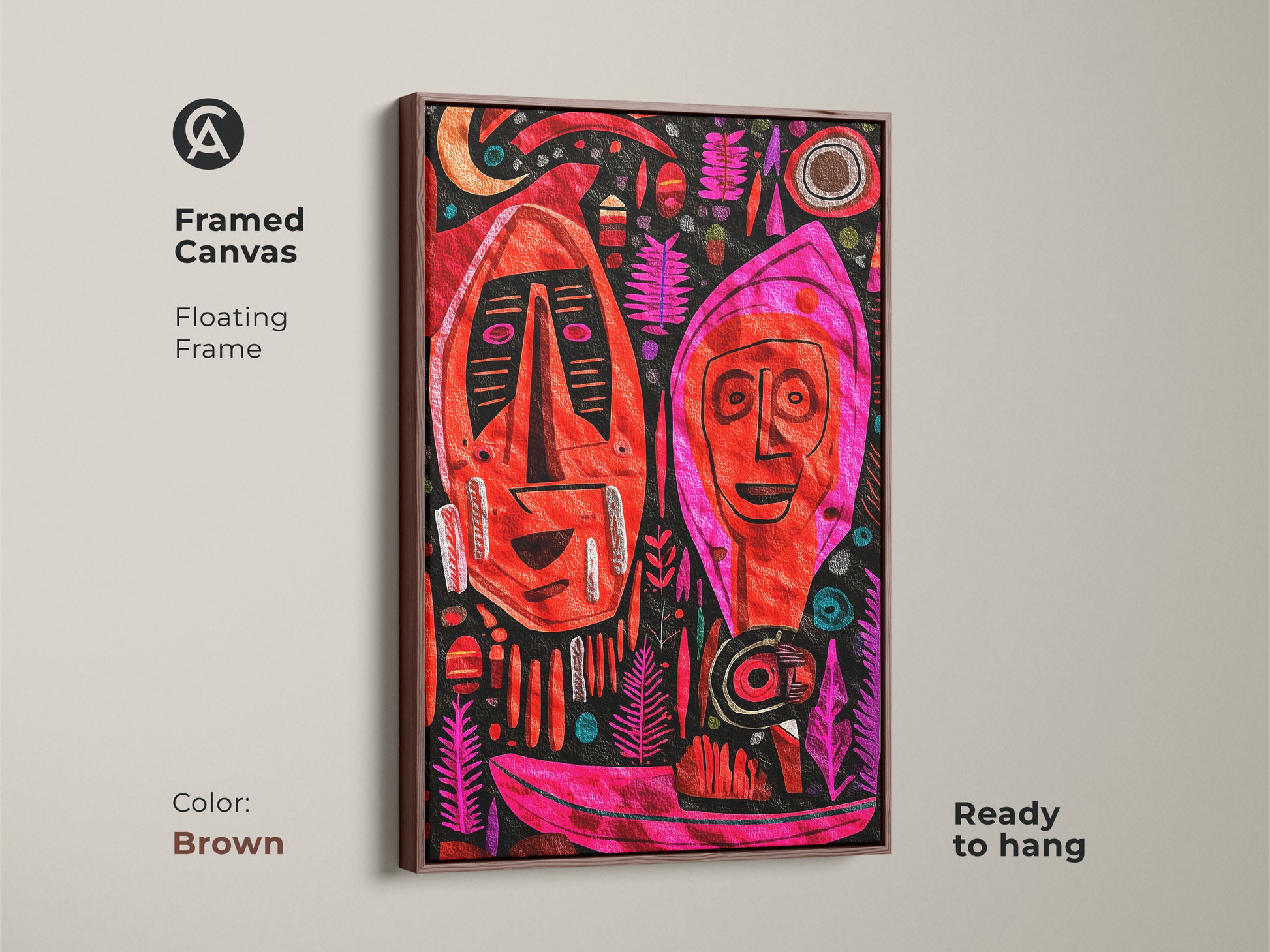 The framed canvas features tribal masks in red pink and magenta with a brown floating frame. The warm toned wood complements the primitive home art. It’s a colorful boho art piece for collectors.