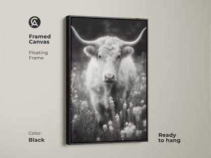Black framed canvas featuring a longhorn in a field. The black and white artwork is ready to hang. The floating frame adds a modern touch. This fine art photograph is a statement piece for your home decor.
