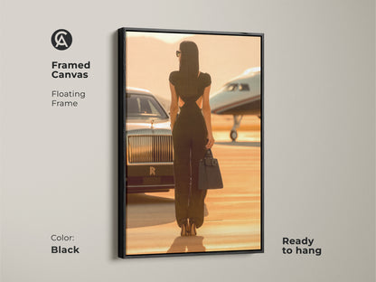 Framed canvas featuring a woman with a private jet and car. The floating frame is black. It's ready to hang. This luxury travel canvas art enhances sophisticated living rooms. A perfect blend of high fashion and warm tones.