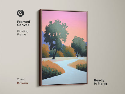 Brown framed canvas displaying modern abstract landscape. Contemporary trees wall art with a floating frame is featured. The pink and orange sky artwork brings life to the nature scene. A stylized nature painting is ready to hang.