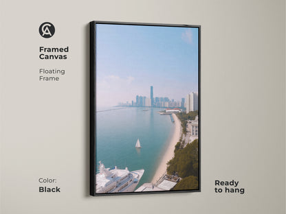 A framed canvas showing coastal cityscape art with a yacht and sailboat. This floating frame artwork is ready to hang and features a black frame. The ocean view art print features modern aqua blue artwork. It is a contemporary cityscape print perfect for travel lovers. The coastal scene offers nautical themed wall decor.