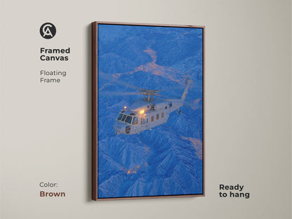 A helicopter is featured over a city nestled in the mountains in this framed canvas artwork. The brown floating frame complements the image's cool tones. This ready-to-hang aviation art adds a touch of adventure to your decor.