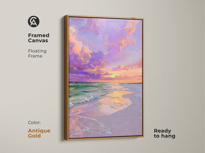 A framed canvas print of a beach sunset. The coastal artwork has a antique gold floating frame. The print features pink and purple clouds over the ocean. This framed canvas is ready to hang and enjoy.