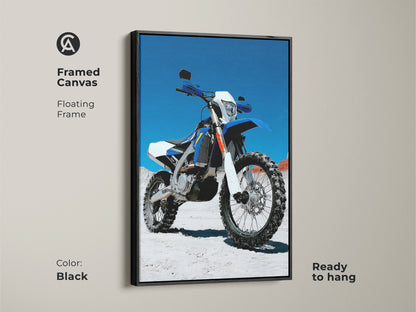 Framed canvas of a blue and white dirt bike. The floating frame enhances the motorcycle artwork. Ready to hang in a garage or man cave. Ideal gift for a motorcycle rider. This piece adds an industrial touch.