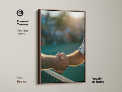 Brown framed canvas art depicting a handshake on the tennis court. The warm-toned floating frame enhances the artwork. This canvas print is perfect for home or office. Ready to hang and enjoy.