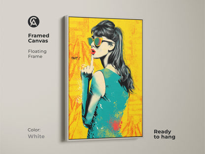 Framed canvas of a pop art woman. It features a white floating frame and is ready to hang. This retro style home decor includes a fashion wall hanging. The yellow orange and teal print adds a unique touch. This canvas artwork is perfect for eclectic interiors.