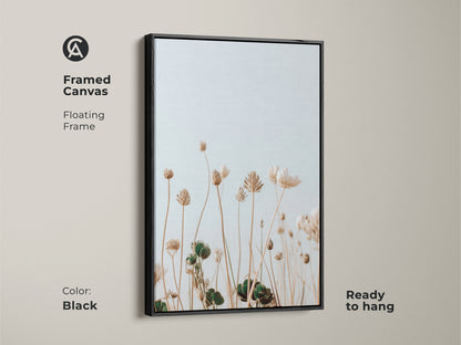 Framed canvas featuring light blue and cream wildflowers. The black floating frame accentuates this minimalist botanical artwork. Perfect for adding a touch of nature to your bedroom decor. It is ready to hang. Ideal for plant lovers seeking a neutral boho art piece for their home.