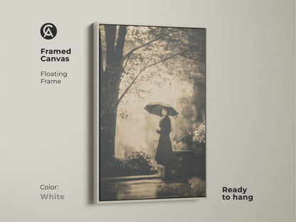 Framed canvas art showcasing a woman with an umbrella. The floating frame is in white. This ready-to-hang piece offers a clean aesthetic. The white frame enhances the vintage art print.
