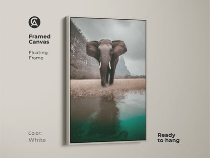 Framed canvas featuring an elephant in a wildlife savanna landscape is ready to hang. White floating frame enhances the photorealistic animal artwork. Perfect for eclectic home decor. This animal print adds a touch of nature-inspired charm to any room. Great housewarming gift for animal lovers.