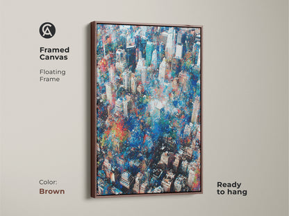 Framed canvas artwork of an aerial cityscape. The floating frame is brown adding a rustic touch. The artwork is ready to hang and enjoy. The brown frame complements the artwork's vibrant blues and reds. The art piece is very unique.