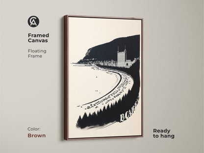 Framed canvas of a vintage coastal town. The monochrome seaside town is a neutral beach artwork print that is ready to hang. Features a floating frame with brown color.