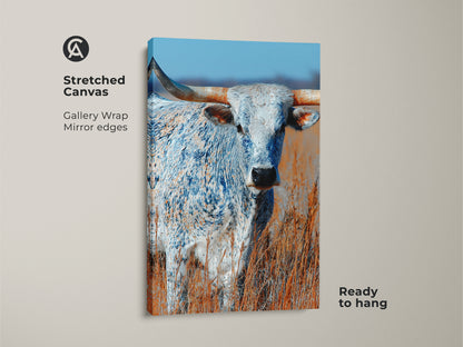This stretched canvas features a longhorn bull. The animal is standing in a field. The gallery wrap has mirror edges. This canvas print is ready to hang. Add this beautiful animal art to your walls today.