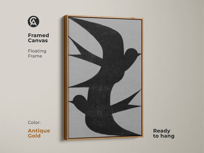 Framed canvas of minimalist wall art featuring an abstract black swallow flock. The floating frame color is antique gold. This modern grey nature decor is ready to hang. Consider this housewarming gift canvas for minimalist homes. The abstract artwork of birds will complement a neutral bedroom.