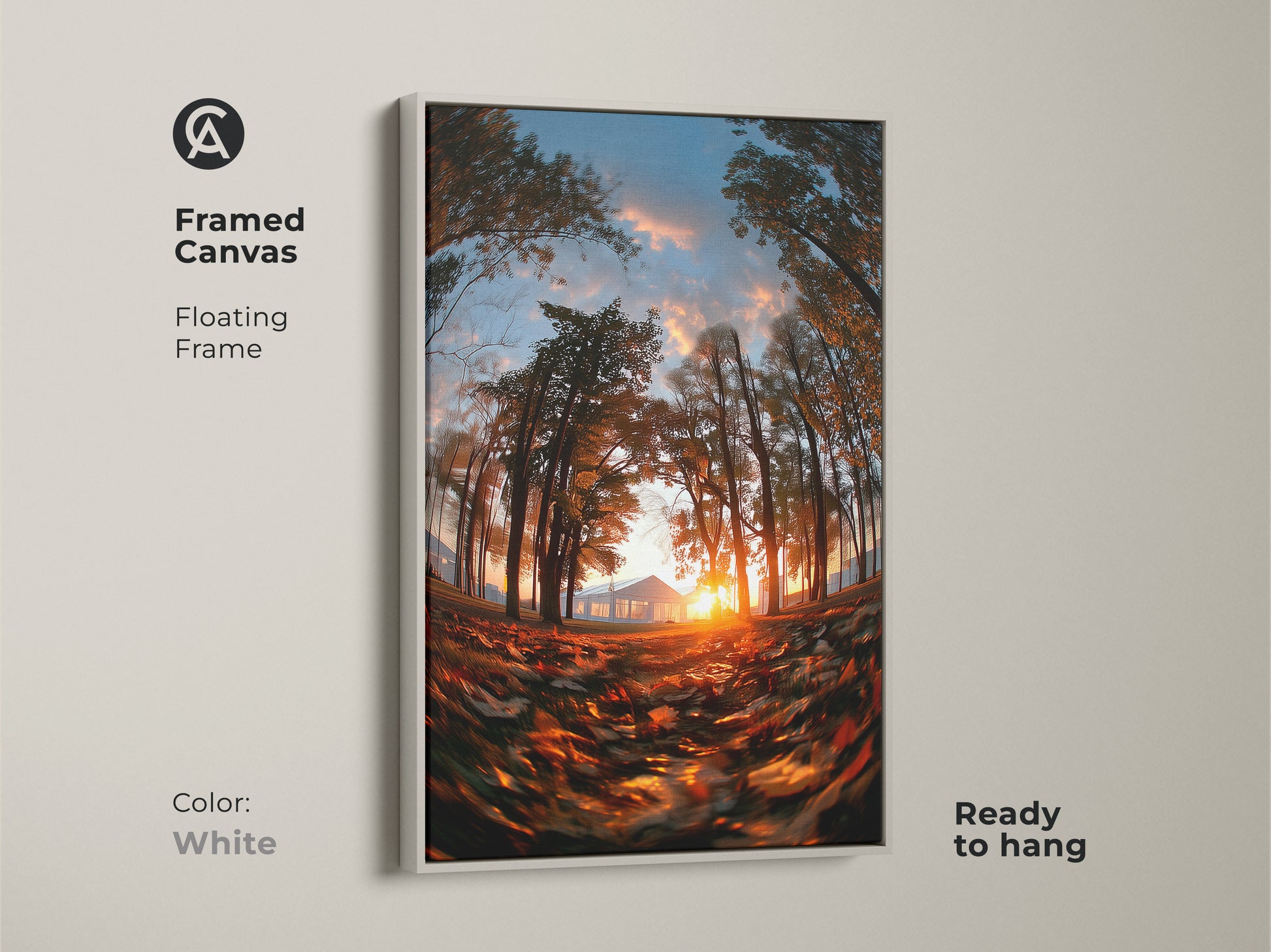 Framed canvas of a sunset through trees with a white floating frame. The sun shines behind a distant house. Fallen leaves cover the ground. This nature art is ready to hang. The white frame offers a clean modern look.