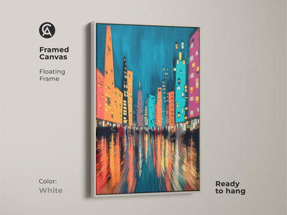 Framed canvas showcasing a modern abstract cityscape artwork. The white floating frame complements the teal blue hues with orange and pink accents. Ready to hang. Great contemporary wall art for a modern apartment or office.