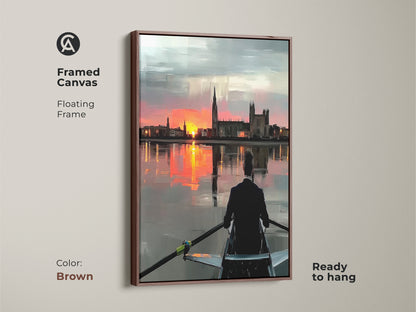 Framed canvas showing rowing art at sunset with a floating brown frame. The impressionistic landscape canvas is ready to hang. Orange pink and grey tones create a modern aesthetic. The cityscape sunset print is ideal for office wall decor. It is a great gift for rowers or athletes. A contemporary office art piece.