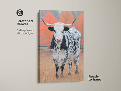 Elevate your space with Longhorn Cow canvas art. This stretched canvas features gallery wrapped edges. The art shows a black and white speckled Longhorn in a field with autumn trees. It is ready to hang