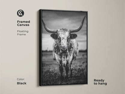 Framed canvas featuring a black and white Texas Longhorn in a floating black frame. This ready-to-hang animal portrait canvas adds character to entryways living rooms or home offices. The rustic ranch decor complements farmhouse or minimalist interiors. It brings a touch of the wild west to any residential space making it an excellent housewarming gift.