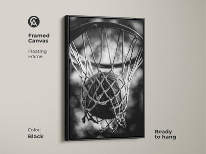Black framed basketball canvas art. This floating frame canvas is ready to hang. The black and white artwork features a basketball in a net. Enhance your decor with sports-themed art.