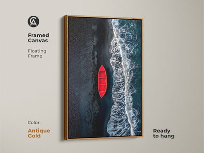 Framed canvas art featuring a red boat on a beach with black sand. The artwork has a beautiful antique gold floating frame. This canvas is ready to hang and will elevate any room's decor. A perfect addition to your art collection.