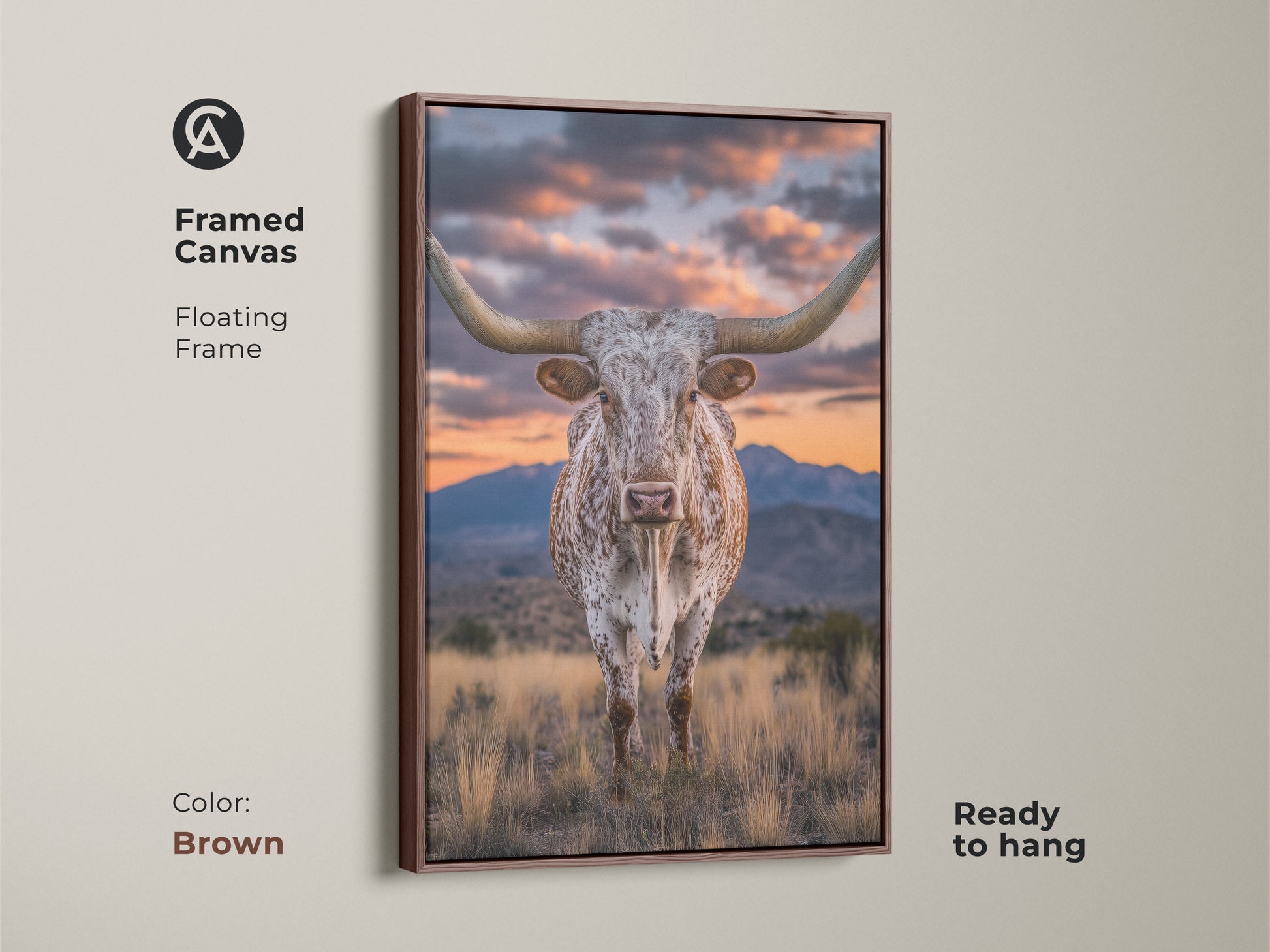 Framed canvas of a longhorn steer with a brown floating frame. The rustic western artwork showcases a mountain sunset. This farmhouse landscape art is ready to hang. It's a great cowboy gift.