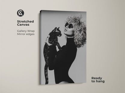 Stretched canvas print showcasing a monochrome portrait of a woman with a cat. This black and white glamour fashion wall art brings contemporary style to your home. Perfect as a unique gift for cat moms this gallery-wrapped canvas is ready to hang adding a touch of elegance to any bedroom.