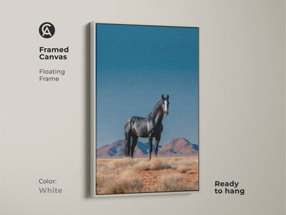 Framed canvas art featuring a black horse in a desert setting with a white floating frame. This wildlife canvas print is ready to hang and adds a clean modern touch. Ideal for farmhouse decor and a thoughtful gift for horse enthusiasts.