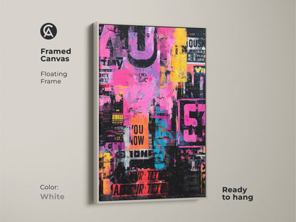 This is a framed canvas print of collage art. The artwork is bright with pink yellow and blue colors. It has stenciled words and numbers. The frame is white and floating. This canvas is ready to hang.