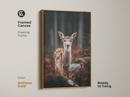 Framed canvas print of a fawn in forest with antique gold frame. The floating frame enhances the photorealistic wildlife art. Ready to hang this rustic artwork adds warmth. Ideal for nature themed decor.
