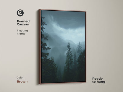 A framed canvas of a moody forest landscape. Dark green pine trees and misty blue mountains create a serene scene. The brown floating frame enhances this nature home decor. Ready to hang artwork makes a thoughtful housewarming gift. Ideal residential forest artwork.