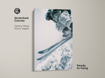 Stretched canvas artwork showcasing a skier performing a jump. The gallery wrap has mirrored edges. This enhances the visual appeal. It's a ready-to-hang piece. Perfect for adding action to any room.
