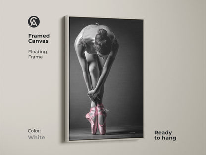 White framed canvas of a ballerina. This art print features a dancer with pink pointe shoes. A floating frame creates a clean look. Ready to hang and complement any interior style easily.
