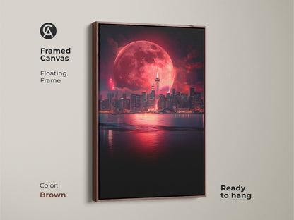 Framed canvas artwork showcasing a surreal cityscape under a crimson moon. The floating brown frame complements the fantasy night sky print. This city view art print is ready to hang offering a touch of the surreal. A great cityscape lover gift