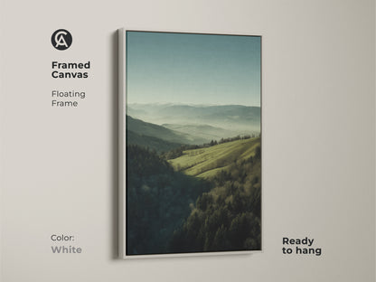 Framed canvas featuring a forest green and misty blue landscape. White floating frame. Ready to hang. The mountain hills nature wall art is ideal for bedroom decor. It makes a great housewarming gift for outdoor enthusiasts. The artwork brings a serene escape.
