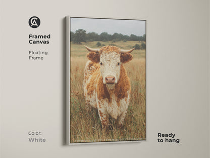 This framed canvas displays a cow portrait with a floating frame in white. The cow stands in a field of dry grass. Ready to hang the canvas brings a clean look to animal art. The bright frame highlights the subject.