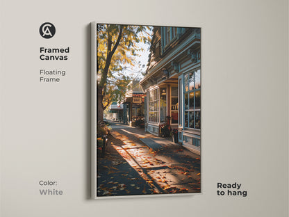 Framed canvas print of a golden autumn street scene. White floating frame makes the traditional artwork pop. Fallen leaves and warm light create a cozy feel. Ready to hang for easy fall decorating. This is high-quality seasonal art.