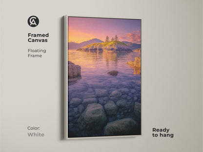 Framed Canvas Island Seascape with a white floating frame. The Coastal Sunset Wall Art features calming ocean landscape photography. The artwork shows a rocky shoreline and serene island. The orange and pink sky art is ready to hang.