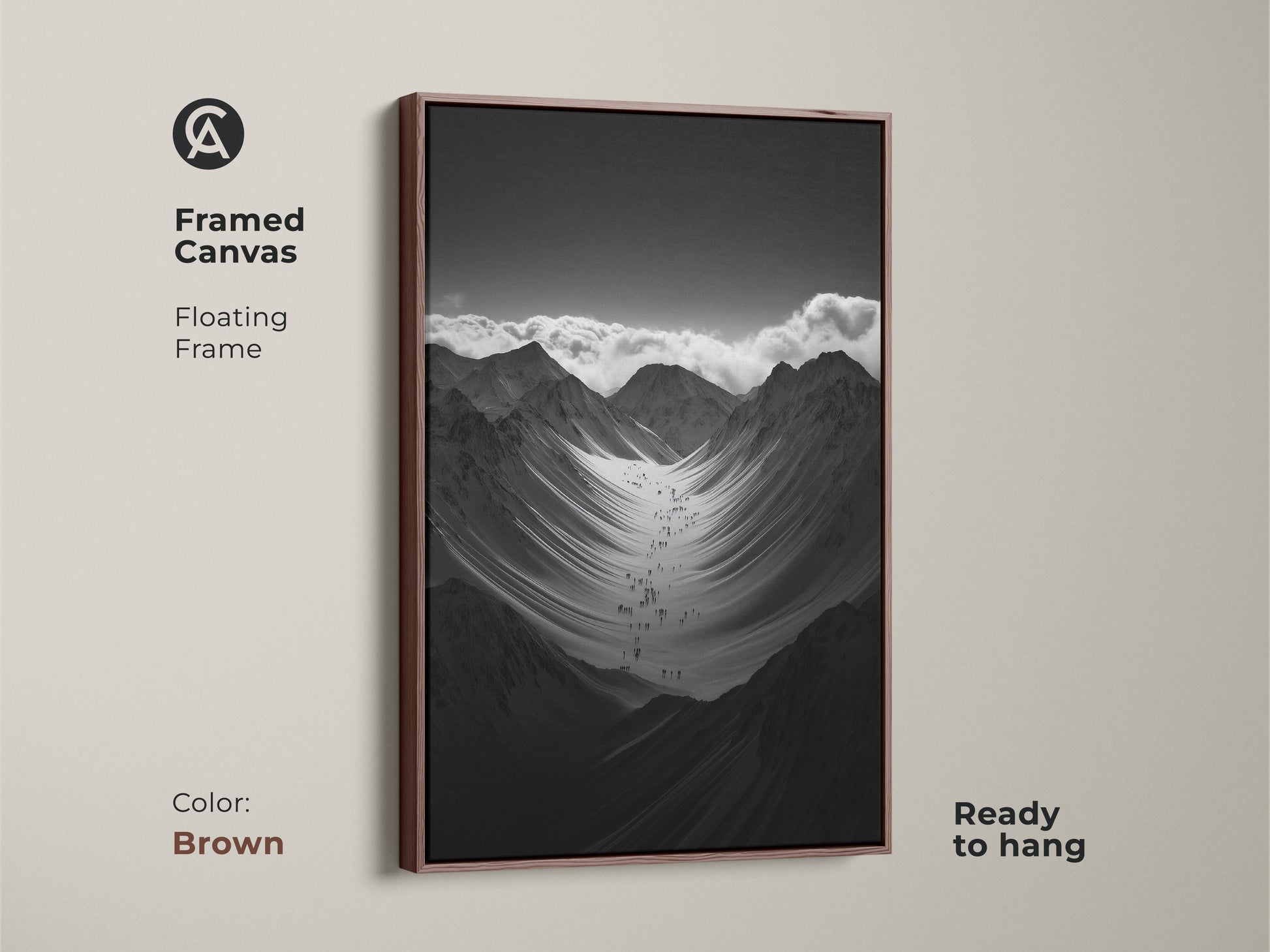 Framed black and white mountain art print with a brown floating frame. This monochrome canvas art is ready to hang. The hikers are ascending a vast snowy mountain range. This nature scenery wall art adds adventure to any space.