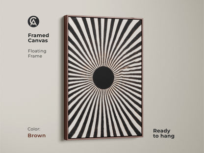 Framed canvas featuring an abstract geometric sun print. This floating frame enhances the black and white artwork. The brown frame complements the mid-century modern art piece. This monochrome sunburst print is ready to hang. It's a minimalist radial wall decor suitable for living rooms. The graphic radial art adds sophistication to any space.