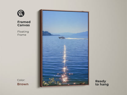 Brown framed canvas showcasing a boat on blue water. The sparkling ocean artwork shows a realistic lake landscape. This ready to hang piece will enhance coastal bedroom wall decor for boat lovers. Summer water scene art makes great nautical home decor. Modern boat artwork for calm spaces.