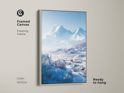 A framed canvas print with a serene winter mountain scene. A white floating frame borders the artwork. The art print shows snow-covered houses in a valley. This ready-to-hang print adds a touch of nature.