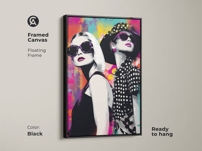 Framed canvas with a black floating frame featuring a pop art portrait of two women in sunglasses. The abstract background showcases magenta teal and yellow tones. It is ready to hang this contemporary artwork adds chic style to any space. Perfect for modern living room or bedroom decor. A fashionable piece.