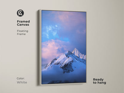Framed canvas print of a snowy mountain with a white floating frame. This blue nature art is ready to hang. The photorealistic artwork adds a modern touch. Perfect wall decor for bedrooms. An outdoor lover gift.